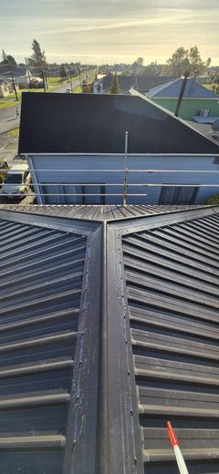 Ridge line view down a new dark roof towards the sea