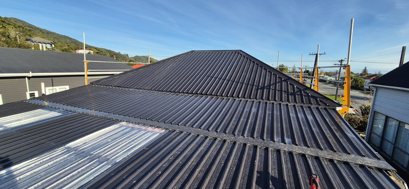 Re-roof in progress — new long-run steel going down over old roof